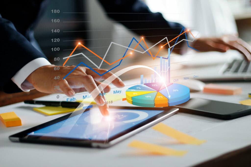 Businessman using Tablet & Laptop Analyzing Sales Data and Economic Growth Graph Chart | Growth99 | Website Development, Digital Marketing, SEO in USA